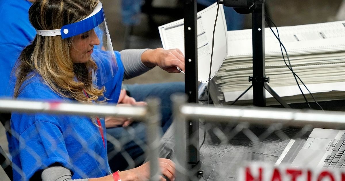 Contractors working for the Florida-based company Cyber Ninjas examine and recount ballots cast in Maricopa County, Arizona, in the November election at Veterans Memorial Coliseum in Phoenix on May 6.