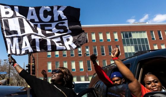 A woman holds a Black Lives Matter flag during the funeral service of Daunte Wright outside the Shiloh Temple International Ministries in Minneapolis on April 22, 2021.