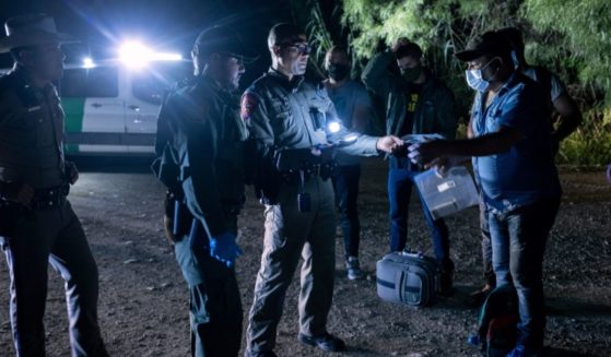 Venezuelan immigrants encounter Texas state troopers and a U.S. Border Patrol agent after crossing the Rio Grande on Tuesday in Del Rio, Texas.