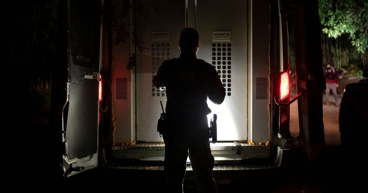 A Border Patrol agent closes the door of a transport vehicle after loading a group of illegal immigrants who were apprehended near the border between Mexico and the United States in Del Rio, Texas, on May 16.