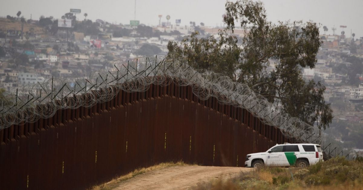 A Border Patrol vehicle sits next to a new section of the steel bollard-style wall along the U.S.-Mexico border between Tijuana, left, and San Diego on May 10.