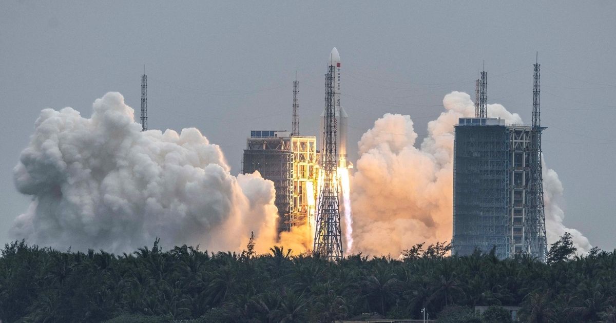 People watch a Long March 5B rocket, carrying China's Tianhe space station core module, as it lifts off from the Wenchang Space Launch Center in southern China's Hainan province on April 29, 2021.