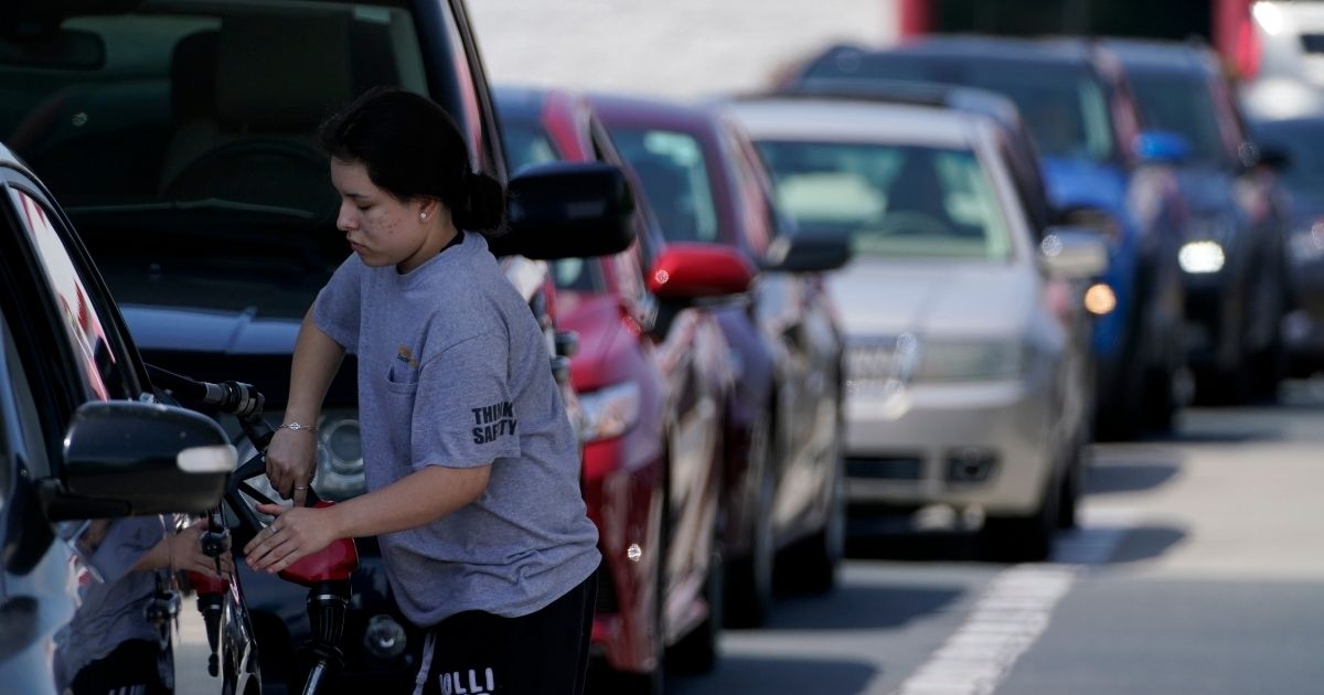 A customer pumps gas at Costco as others wait in line on Tuesday in Charlotte, North Carolina.