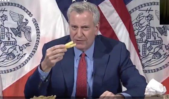 Mayor Bill de Blasio eats french fries during a news conference.