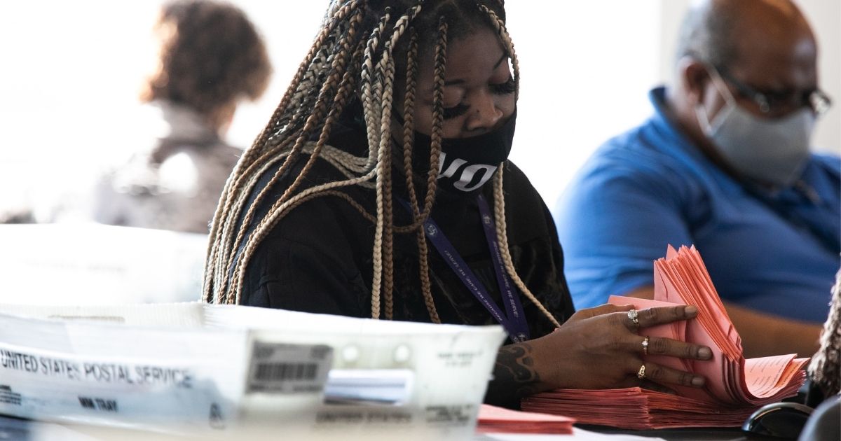 A Fulton County worker continue to count absentee ballots at State Farm Arena on Nov. 6, 2020, in Atlanta.