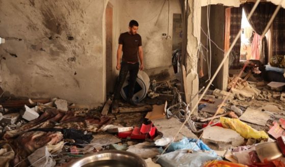 A relative inspects the damage inside a house in Deir el-Balah in the central Gaza Strip, on Wednesday, following an Israeli air strike.