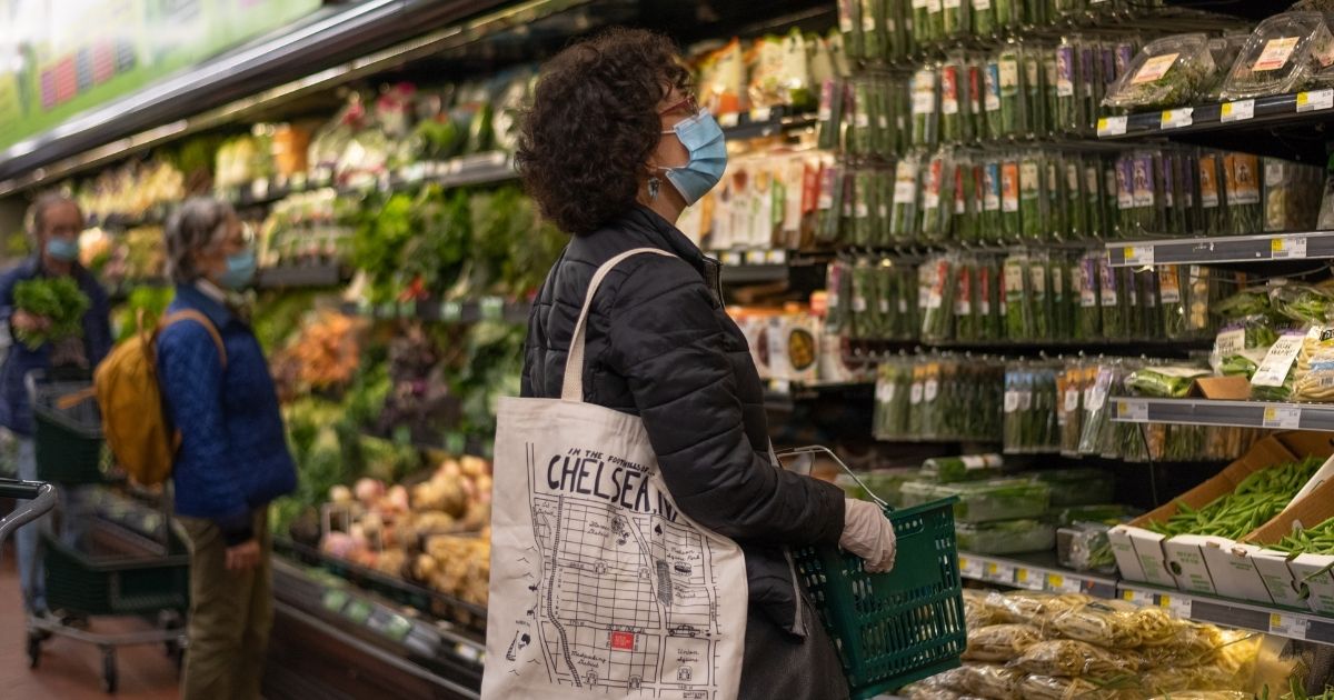 A woman wearing a mask and gloves shops at Fairway supermarket amid the coronavirus pandemic on May 1, 2020, in New York City.