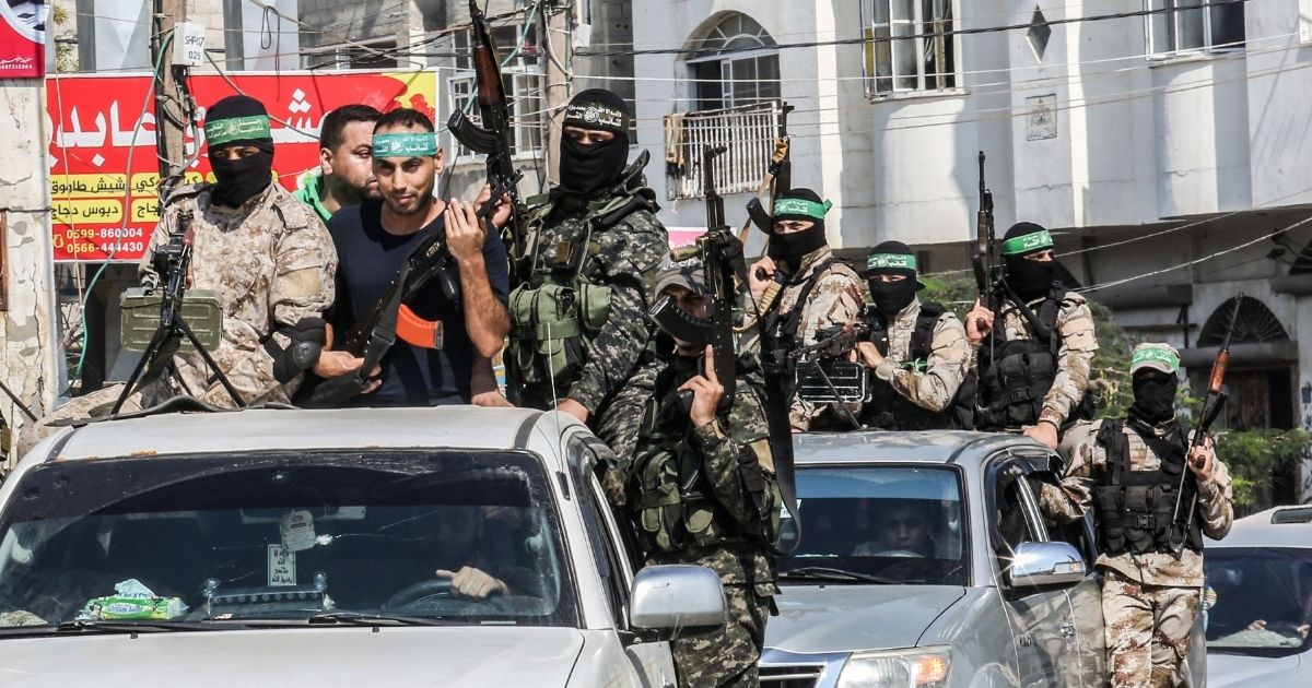 Abdel Halim Badawi, a Palestinian who was held for 18 years in an Israeli prison after he was convicted of being a member of Hamas' armed wing in 2001, rides in the back of a pickup truck with Hamas militants as they celebrate his release in Rafah in the southern Gaza Strip on Oct. 17, 2019.