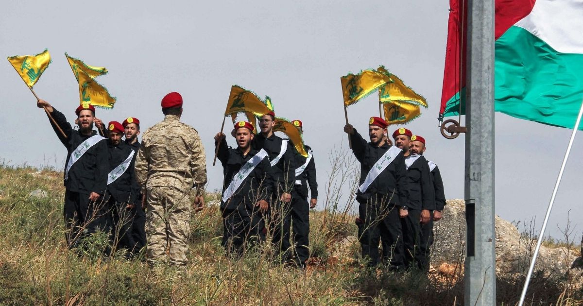 Members of Lebanon's Hezbollah chant during a ceremony including raising the Palestinian flag on a hill by the southern border facing the Israeli northern town of Metula on Friday.