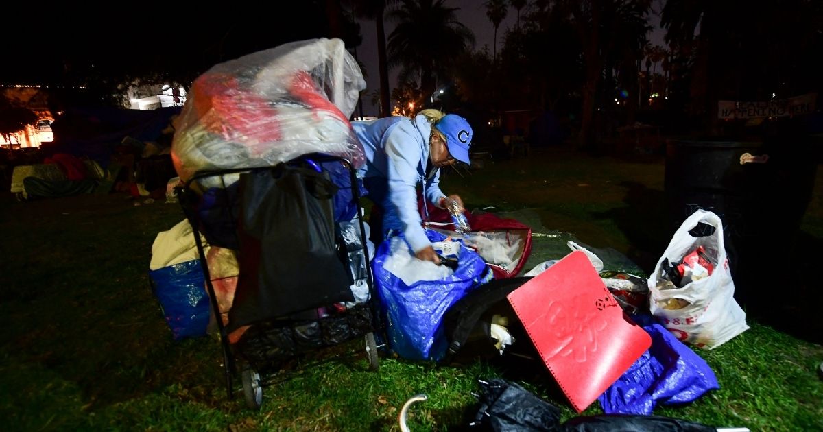 A homeless woman packs her belongings ahead of an expected clearing out of the homeless encampment at Echo Park Lake in Los Angeles, on March 24, 2021.