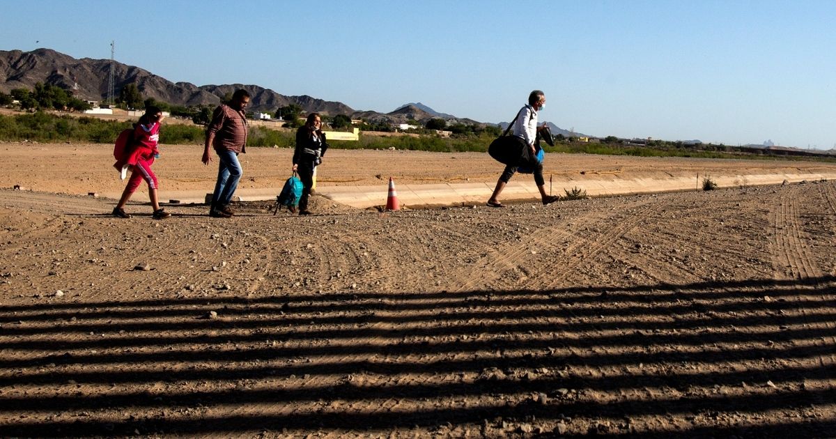 Migrants from Colombia cross the United States and Mexico border to turn themselves over to authorities on Thursday in Yuma, Arizona.