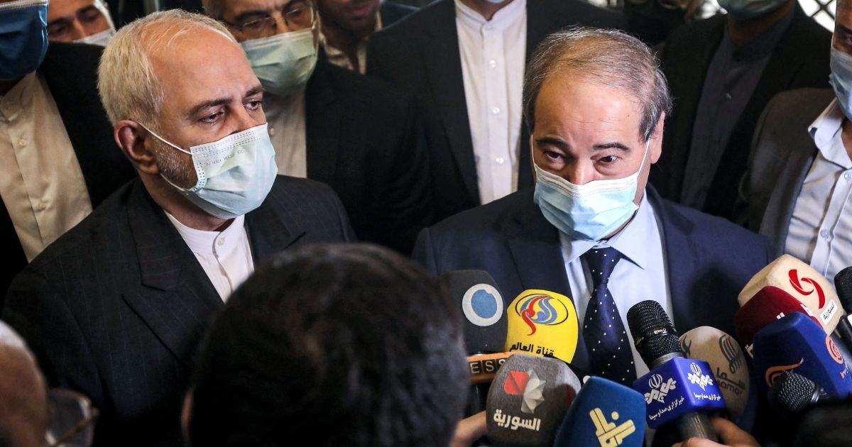 Iran's Foreign Minister Mohammad Javad Zarif, left, and Syria's Foreign Minister Faisal Mekdad, right, speak to reporters after their meeting in Damascus on May 12, 2021.