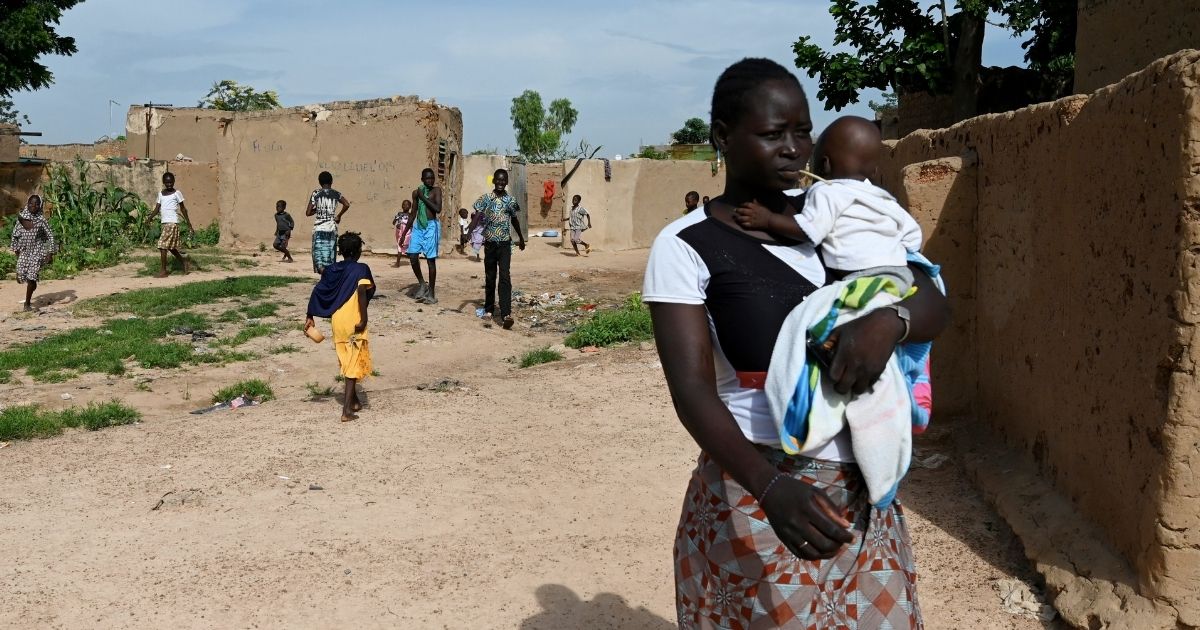 A young woman who is among the displaced due to jihadist violence in northern Burkina Faso holds a baby on Sept. 17, 2019, in the village of Yagma near Ouagadougou.