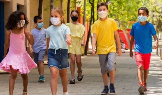 Kids wearing masks are pictured in the stock image above.