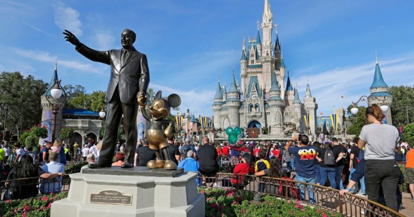 Visitors watch a show near a statue of Walt Disney and Micky Mouse at Walt Disney World's Magic Kingdom in Lake Buena Vista, Florida, on Jan. 9, 2019.