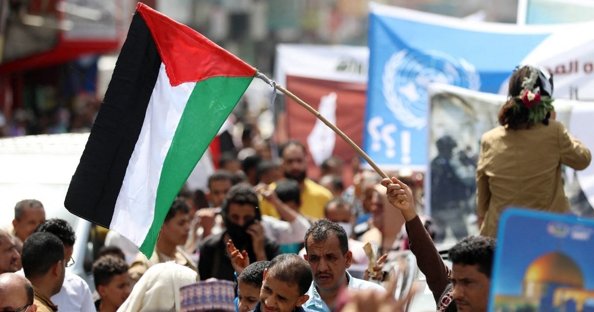 A Yemeni protester waves a Palestinian flag during a demonstration in Taez to denounce ongoing Israeli airstrikes on Wednesday.