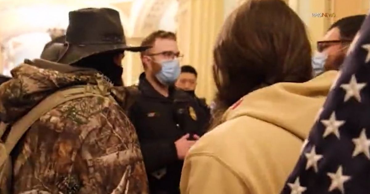 A police officer talks to protesters inside the U.S. Capitol in Washington on Jan. 6.