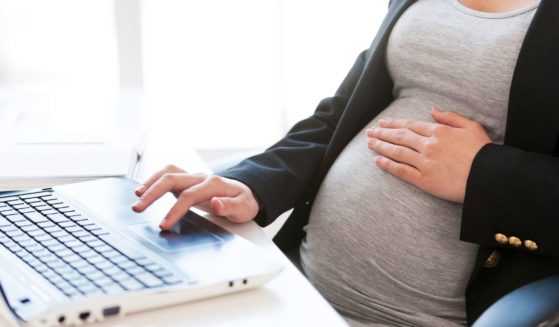 A pregnant mother working on a computer is pictured in the stock image above.