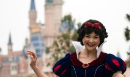 An actress dressed as Snow White poses in front of the Enchanted Storybook Castle at Shanghai Disney Resort in Shanghai on June 15, 2016.