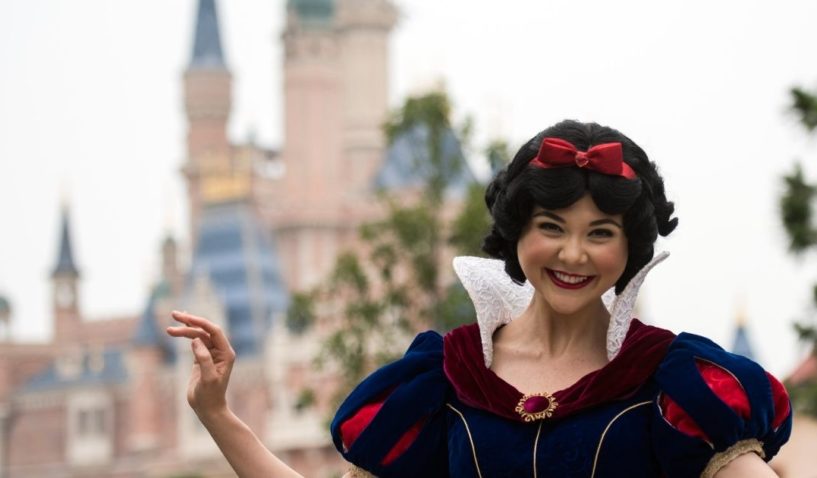 An actress dressed as Snow White poses in front of the Enchanted Storybook Castle at Shanghai Disney Resort in Shanghai on June 15, 2016.