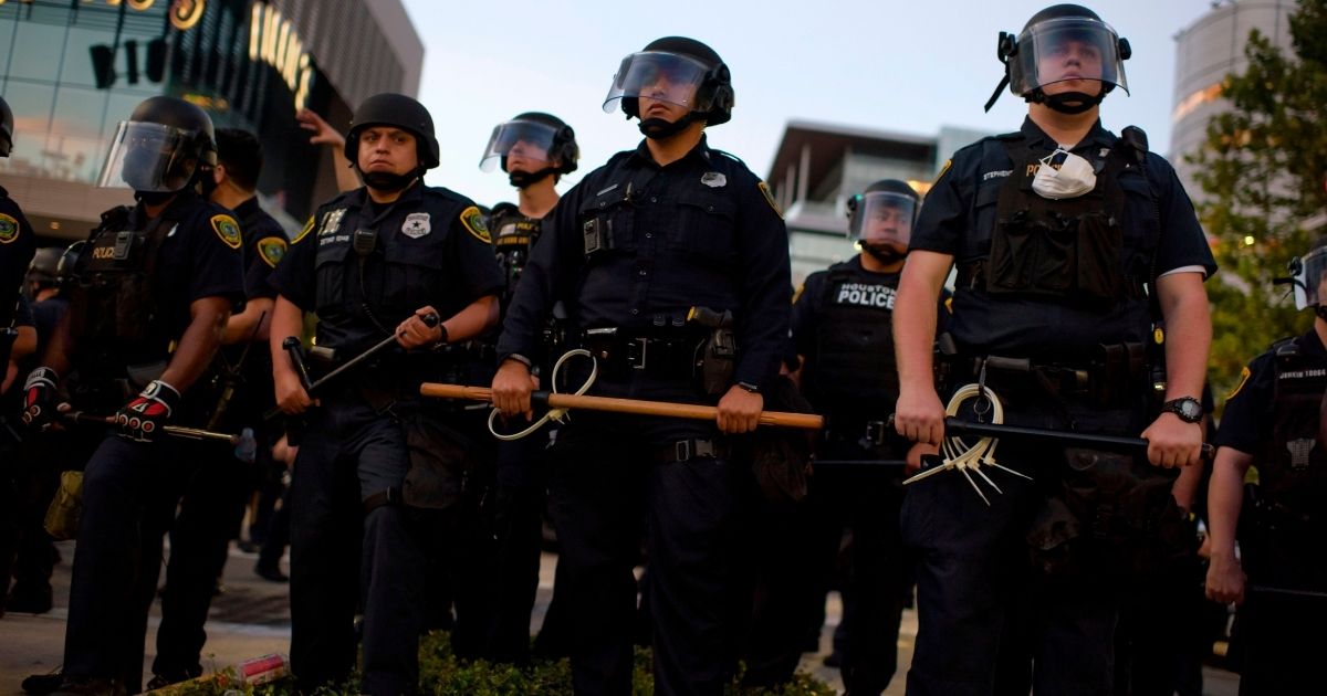 Police officers stand guard after a march in downtown Houston on June 2, 2020.