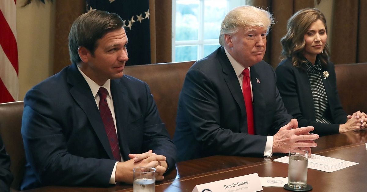 Republican Florida Gov. Ron DeSantis, left, sits next to former President Donald Trump during a meeting in the Cabinet Room at the White House on Dec. 13, 2018, in Washington, D.C.