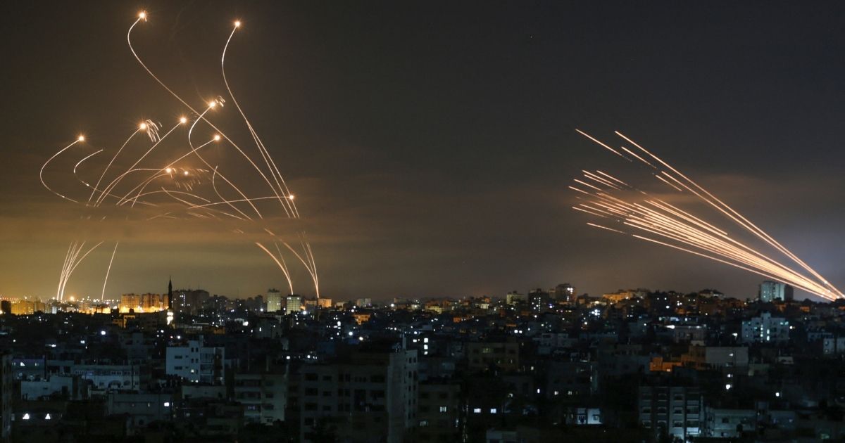 The Israeli Iron Dome missile defense system, left, intercepts rockets, right, fired by Hamas toward southern Israel from Beit Lahia in the northern Gaza Strip as seen in the sky above the Gaza Strip overnight on Friday.
