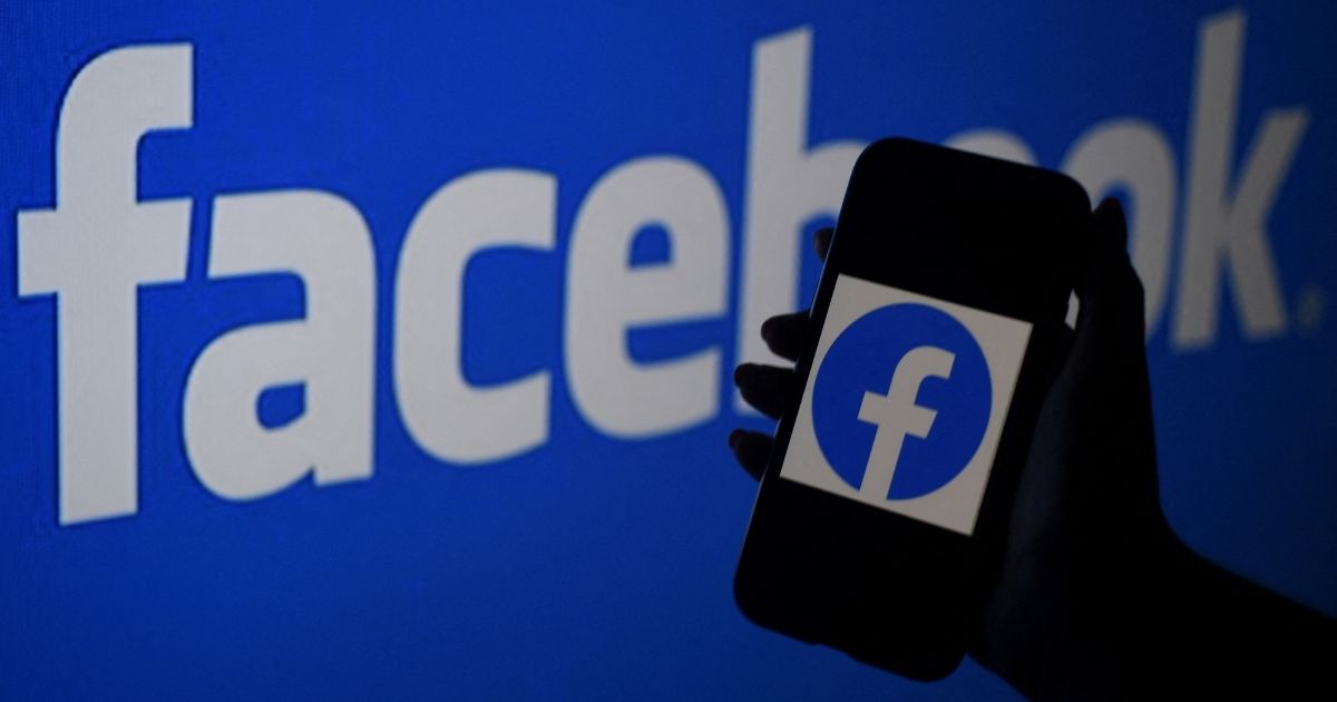 A smartphone screen displays the logo of Facebook on a Facebook website background on April 7 in Arlington, Virginia.
