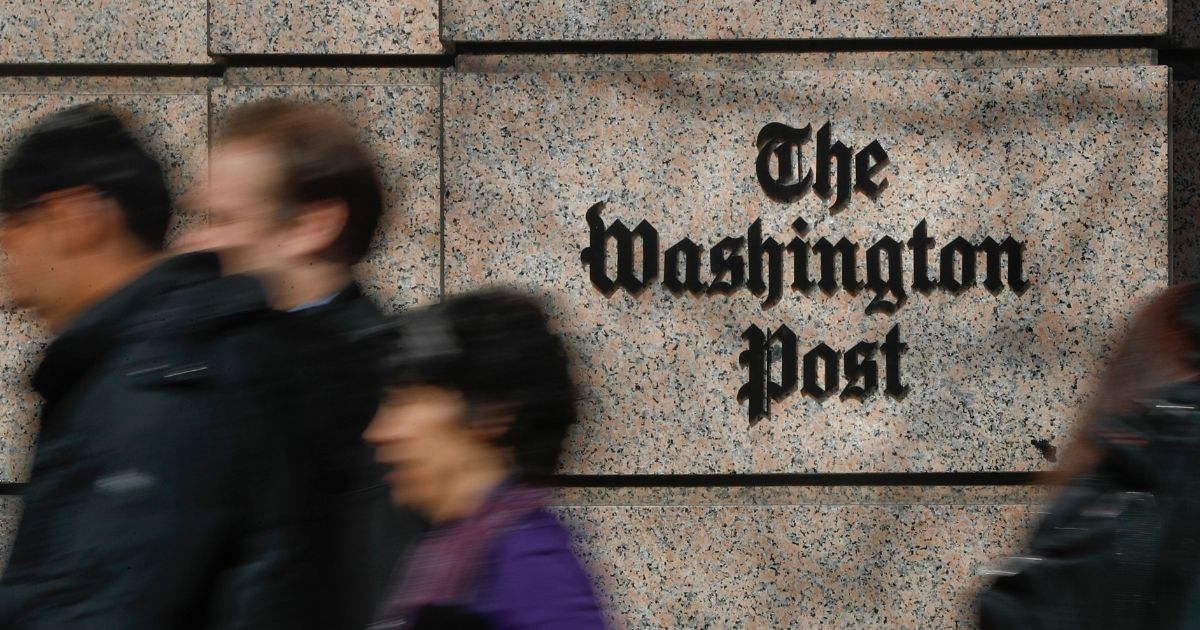 A file photo shows passersby outside the office of The Washington Post in Washington, D.C.