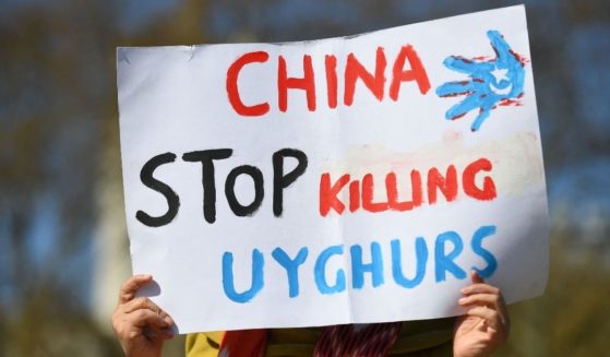 A member of the Uighur community holds a placard as she joins a demonstration to call on the British parliament to vote to recognize the persecution of China's Muslim minority as genocide and crimes against humanity in London on April 22, 2021.