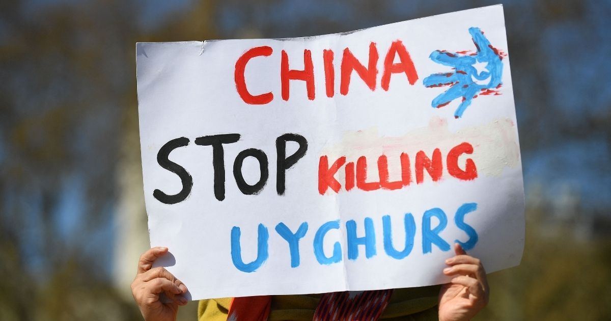 A member of the Uighur community holds a placard as she joins a demonstration to call on the British parliament to vote to recognize the persecution of China's Muslim minority as genocide and crimes against humanity in London on April 22, 2021.