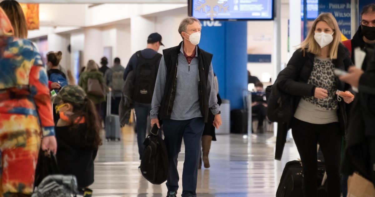 Air travelers wear face masks in Newark Liberty International Airport on Dec. 24, 2020, in New Jersey.