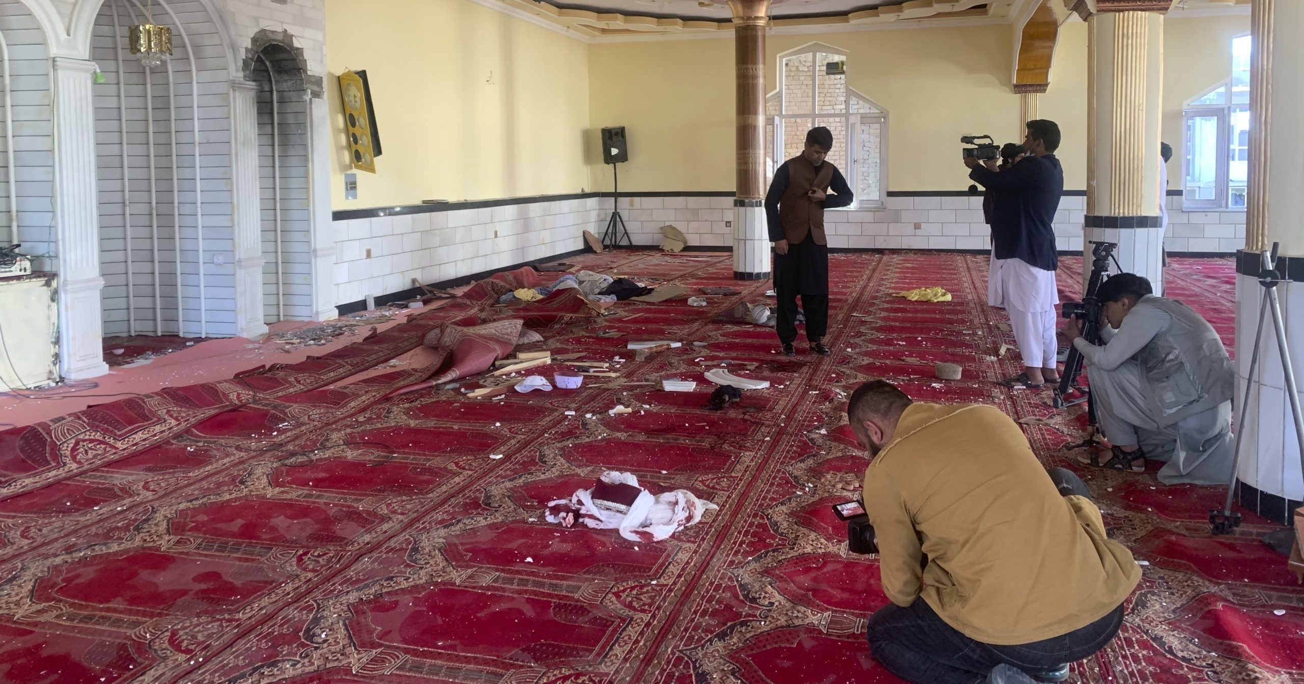 Afghan journalists take photos and film inside a mosque after a bomb explosion in Kabul, Afghanistan, on Friday.