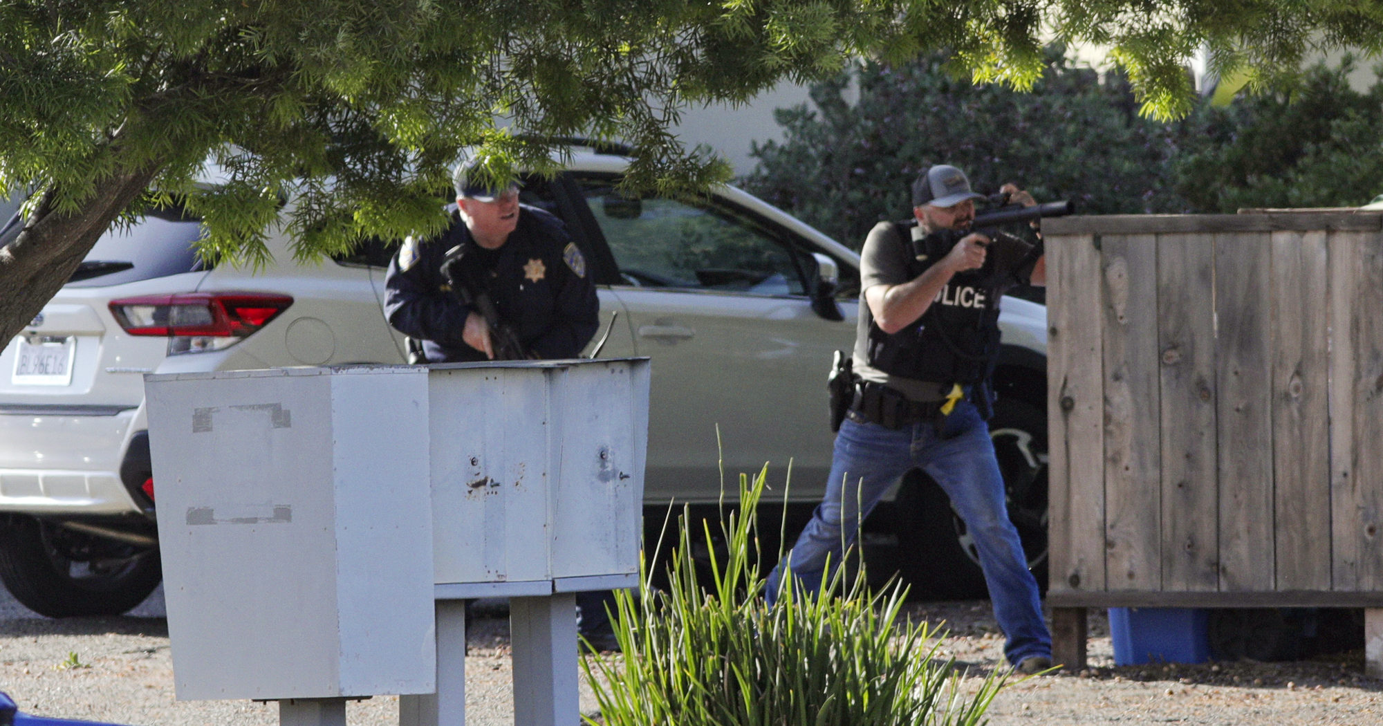 Officers take aim at an apartment across Camilla Court, Monday, May 10, 2021, in San Luis Obispo, Calif. Police said two police officers have been shot while serving a search warrant and the suspect has died. (Officers take aim at an apartment on Monday in San Luis Obispo, California.