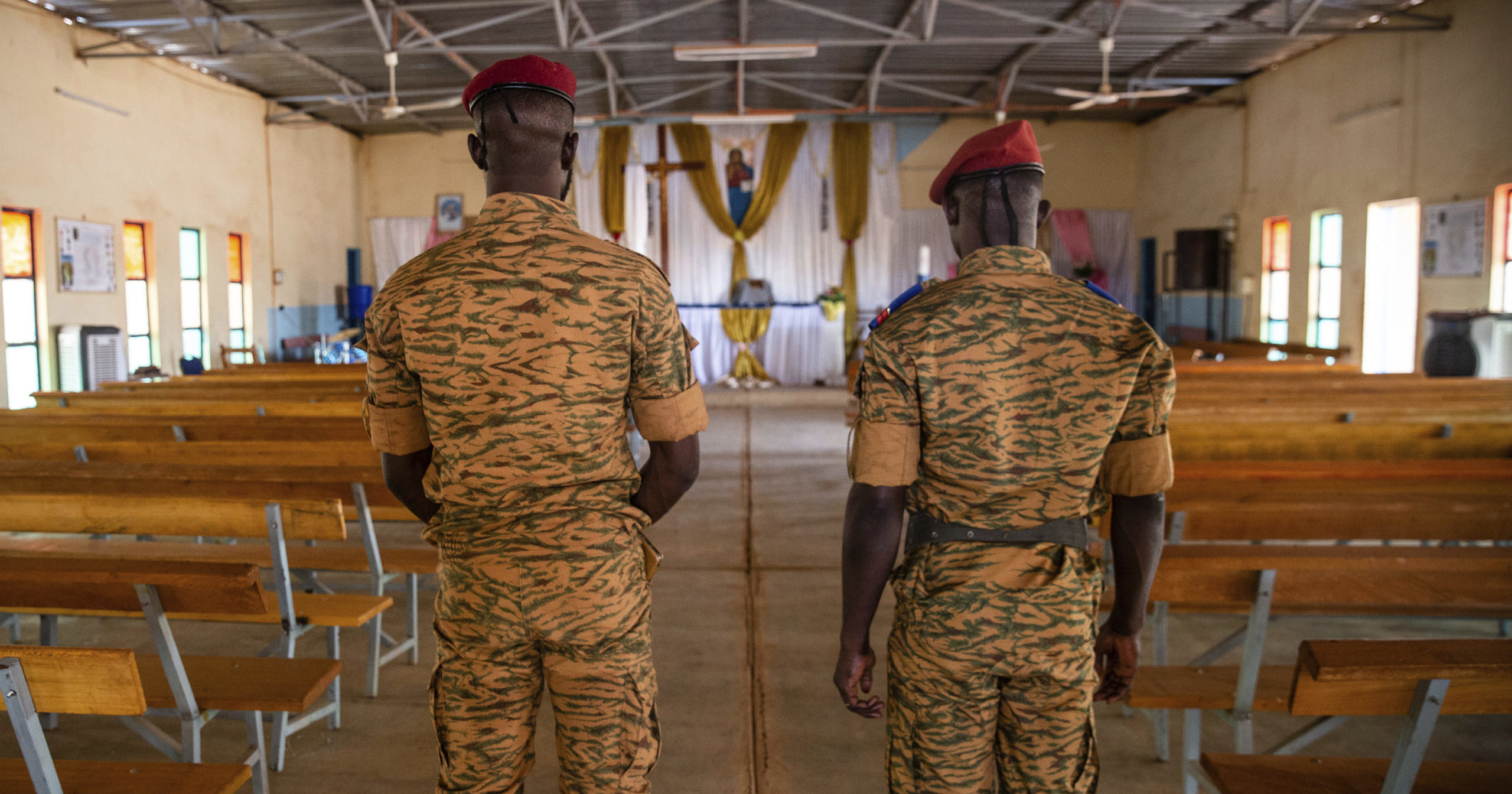 Two soldiers stand in a Catholic church at army barracks in Kaya, Burkina Faso, on April 10, 2021.