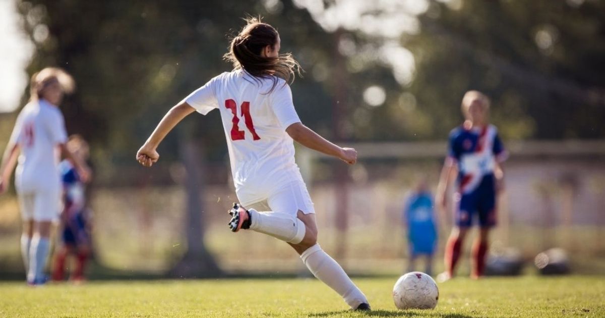 A girl plays soccer in this stock image.