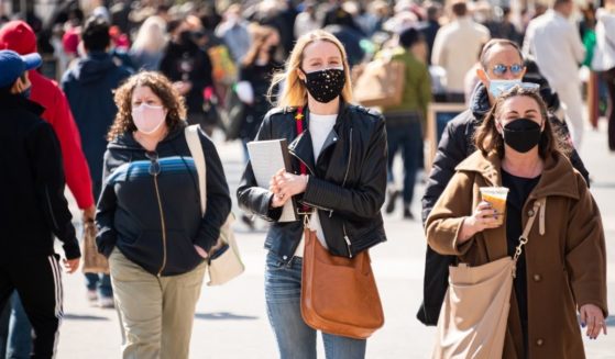 People wear face masks outdoors on March 10, 2021, in New York City.