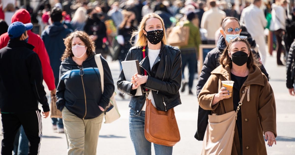 People wear face masks outdoors on March 10, 2021, in New York City.