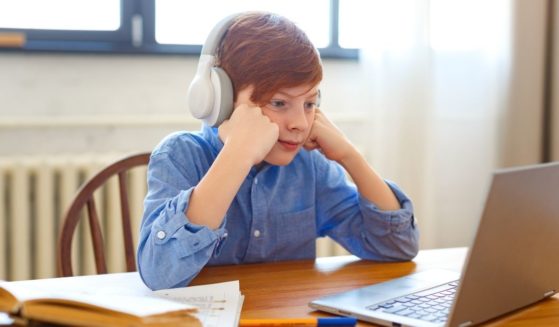 A boy participates in online school in this stock image.