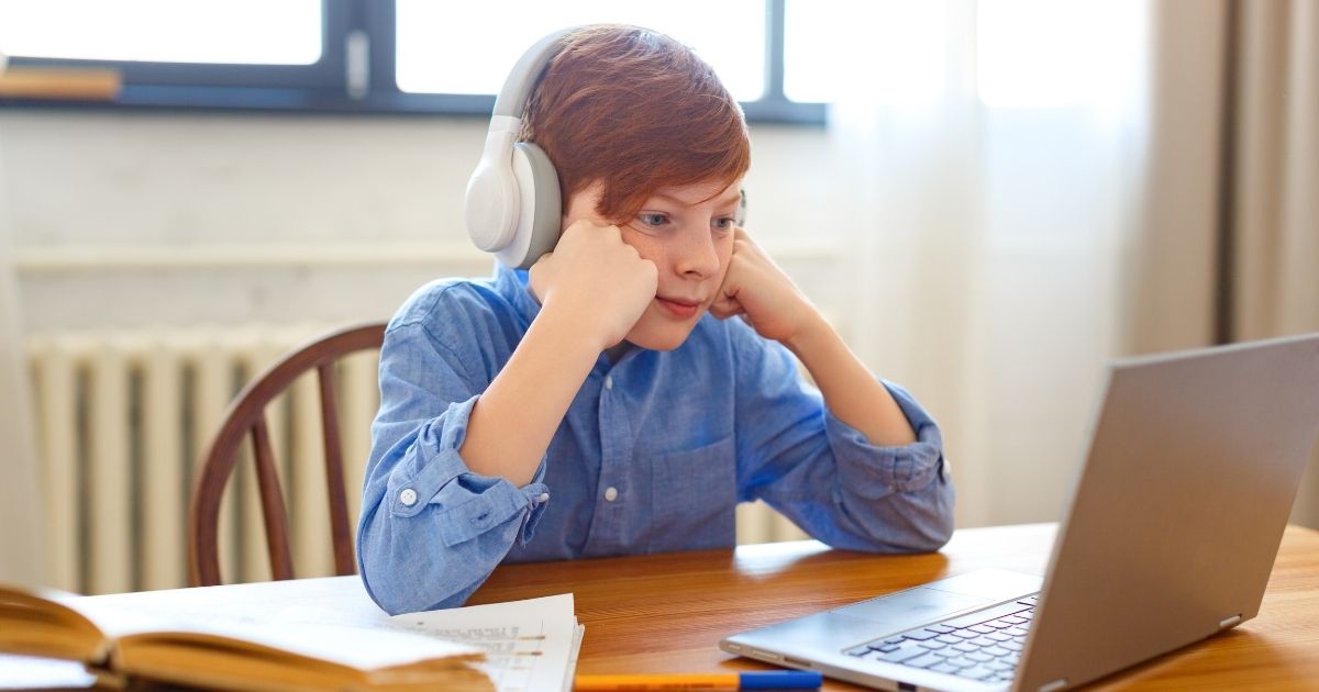 A boy participates in online school in this stock image.