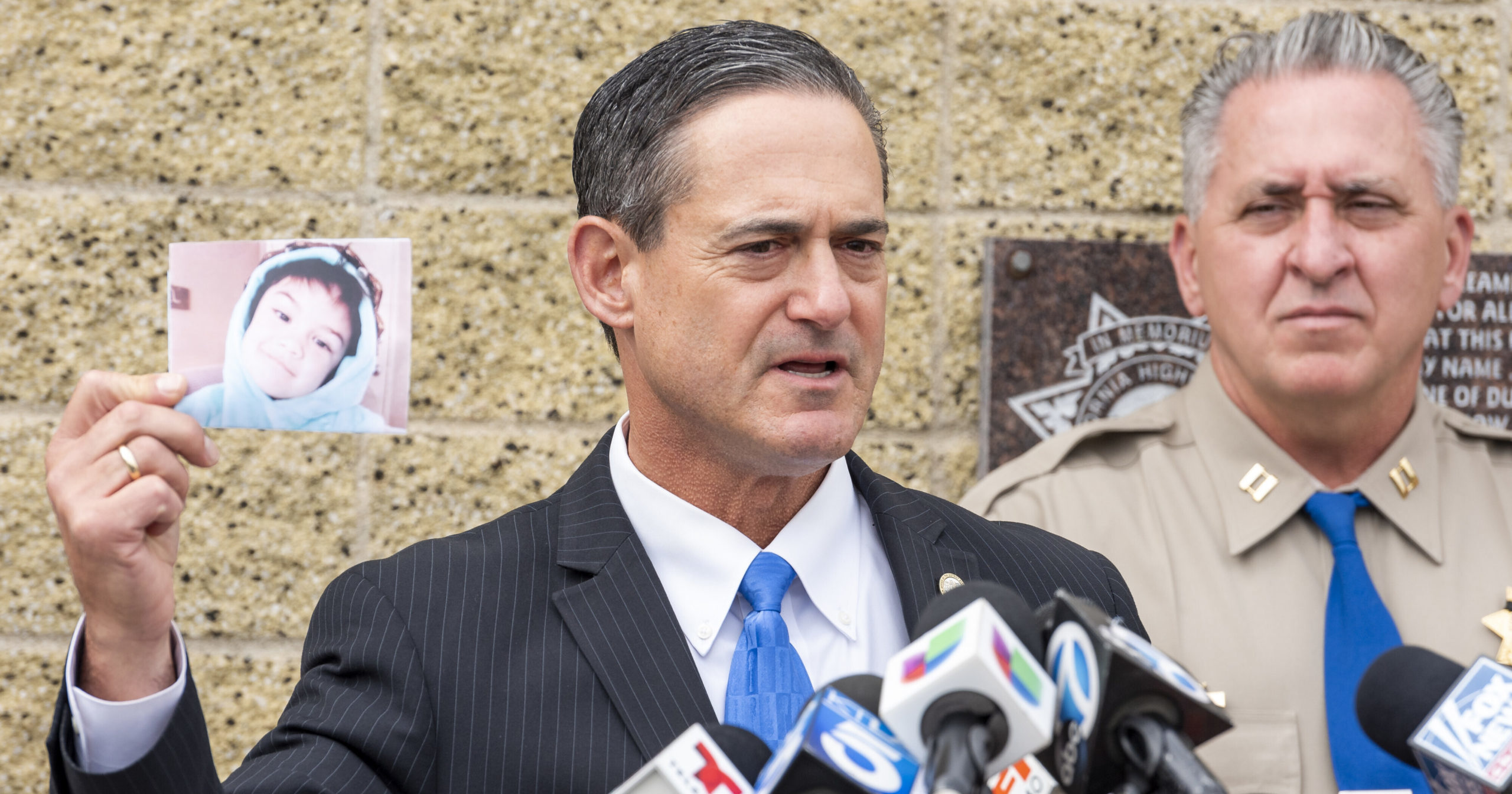 Orange County District Attorney Todd Spitzer holds up a photo of Aiden Leos during a news conference outside in Santa Ana, California, on Monday.