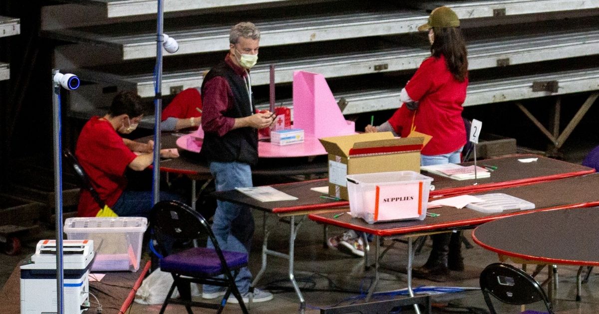 Contractors examine and recount ballots from the 2020 general election at Veterans Memorial Coliseum on May 1, 2021, in Phoenix, Arizona.