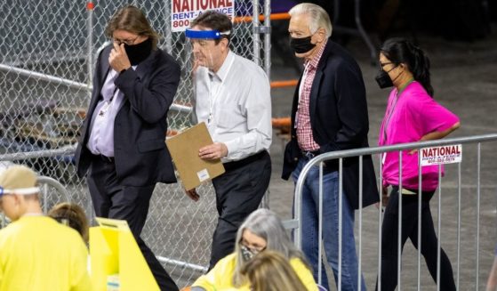 Former Secretary of State Ken Bennett (second from left) works to move ballots from the 2020 general election at Veterans Memorial Coliseum on May 1, 2021, in Phoenix.