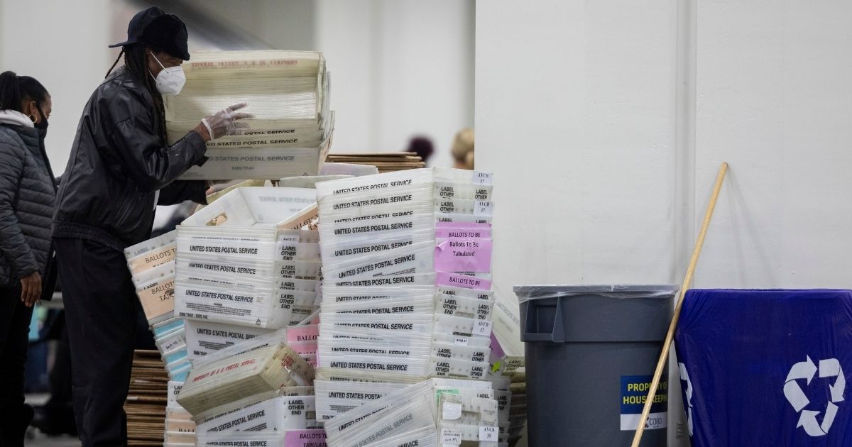 A worker with the Detroit Department of Elections helps stack empty boxes used to organize absentee ballots after nearing the end of the absentee ballot count at the Central Counting Board in the TCF Center on Nov. 4, 2020, in Detroit.