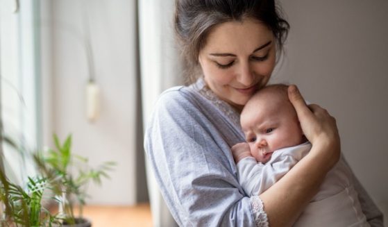 This stock photo portrays a mother holding her newborn baby. New legislation before Congress refers to mothers as "birthing people."