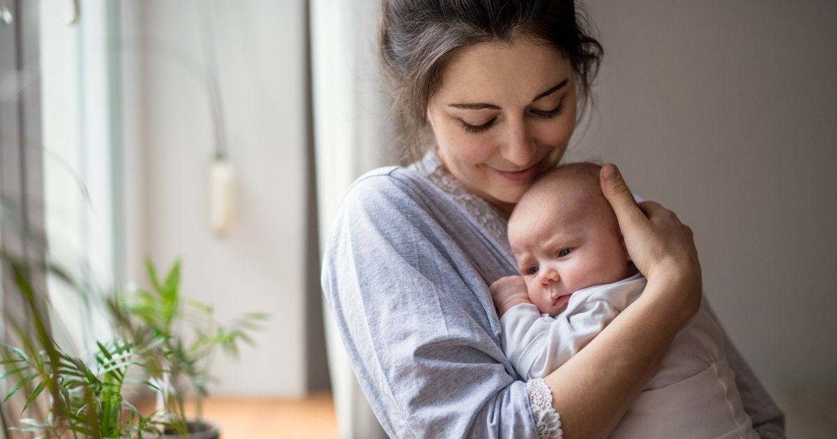 This stock photo portrays a mother holding her newborn baby. New legislation before Congress refers to mothers as "birthing people."