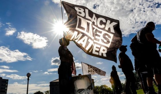 A woman holds a Black Lives Matter flag during an event in remembrance of George Floyd outside the Minnesota State Capitol on May 24, 2021, in Saint Paul, Minnesota.