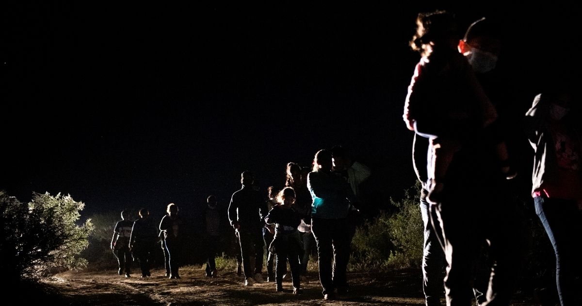 Immigrants seeking asylum walk to be processed at a border patrol processing facility after crossing the Rio Grande into the United States on Thursday in Roma, Texas.