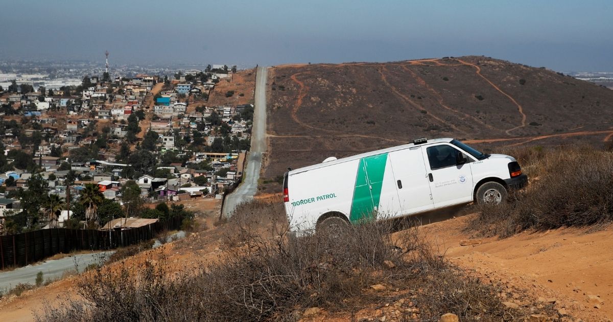 A U.S. Border Patrol van drives up the hill to pick up migrants apprehended trying to illegally cross the U.S.-Mexico border near San Diego on June 28, 2018.