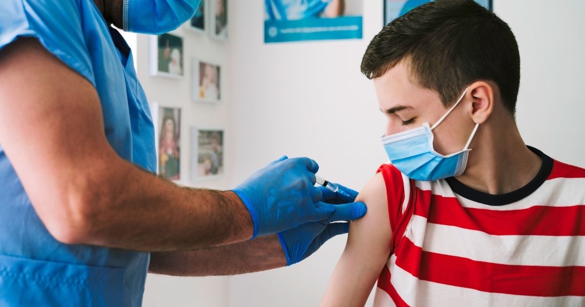 This stock photo shows a teenage boy receiving the COVID-19 vaccine from a health care worker. A Michigan 13-year-old has died after receiving his second dose of the COVID-19 vaccine.